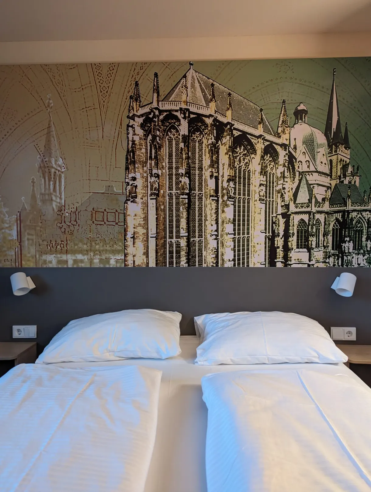 Lit d'hôtel devant une fresque murale représentant la cathédrale