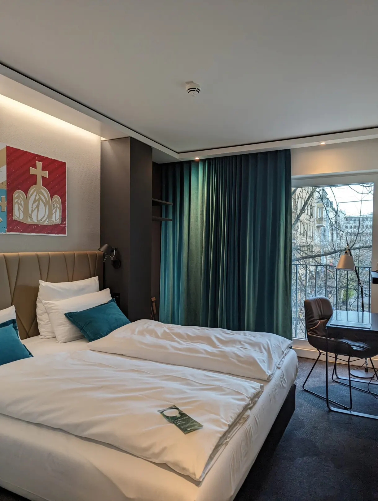 Chambre aux rideaux vert sapin ouvrant sur un balconnet