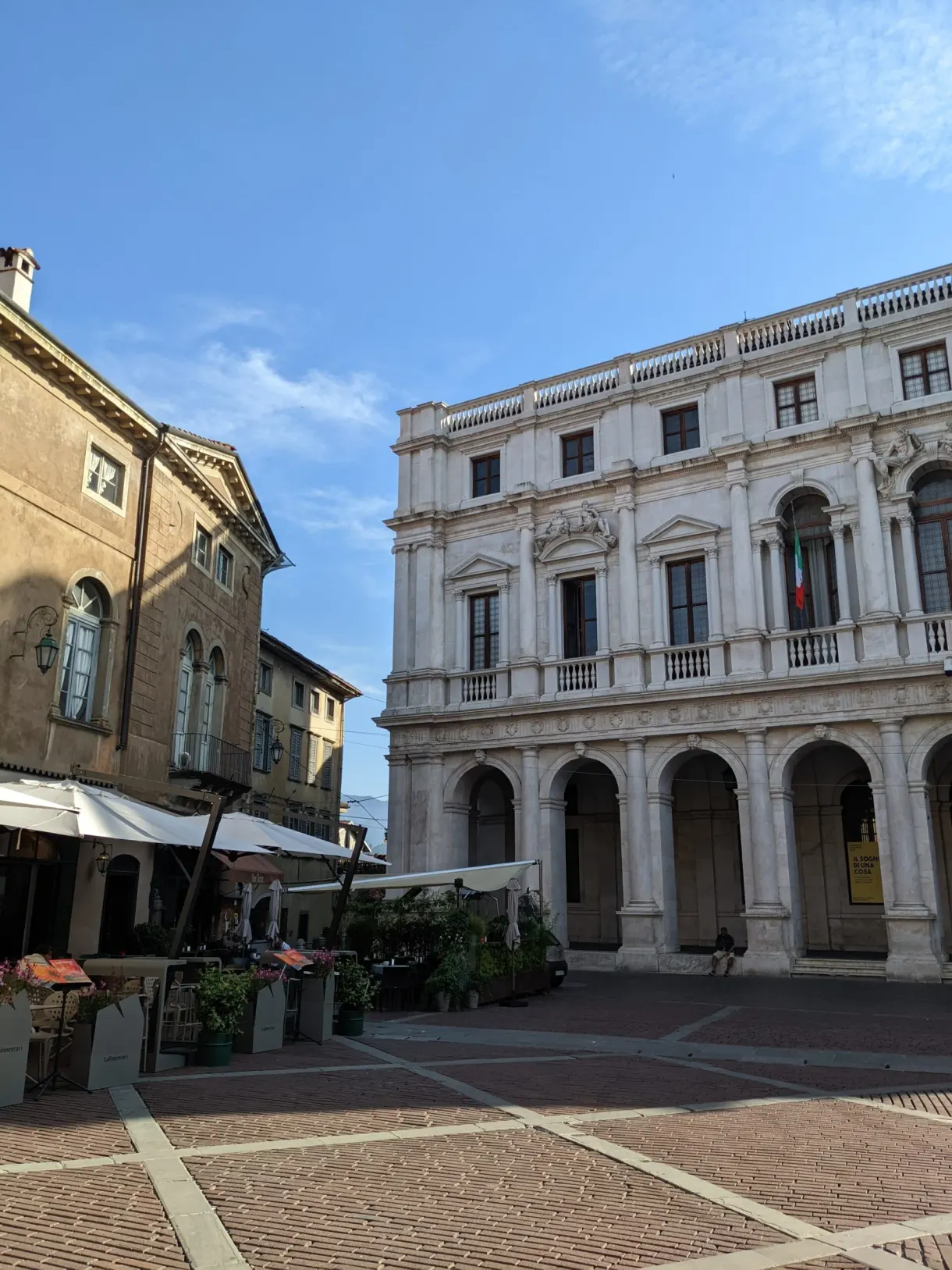 Palais Renaissance à arcades blanches sur une place pavée