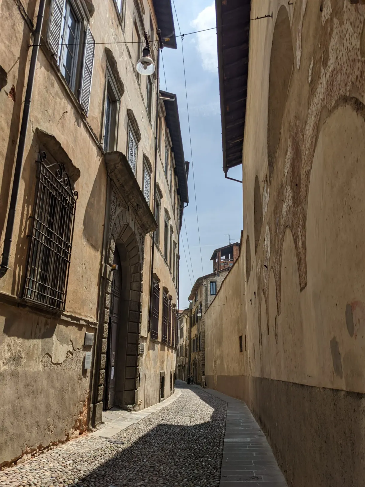 Ruelle étroite en pente entre de hauts murs ocre