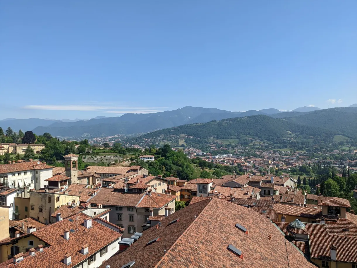 Alignement de toits de tuiles devant les collines lombardes
