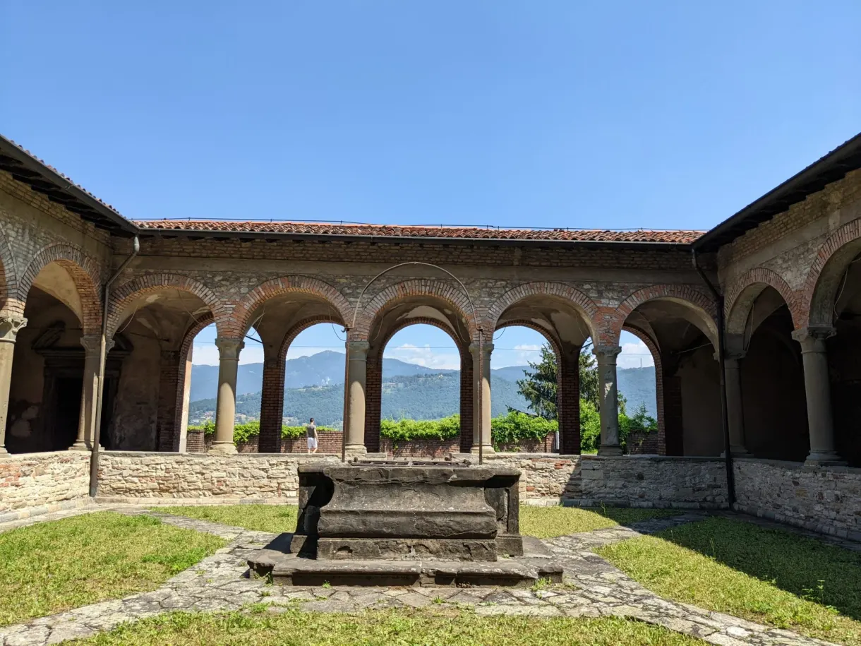 Puits de pierre au centre d'un cloître à colonnades
