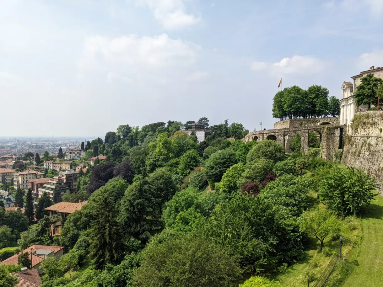 Végétation dense au pied des murailles, plaine au loin