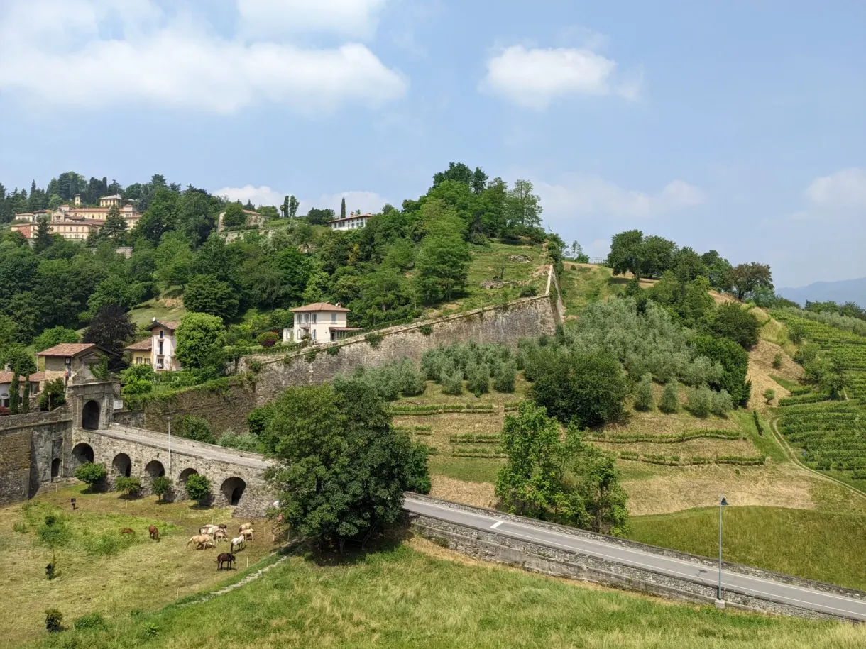Colline cultivée et viaduc à arches au pied des fortifications