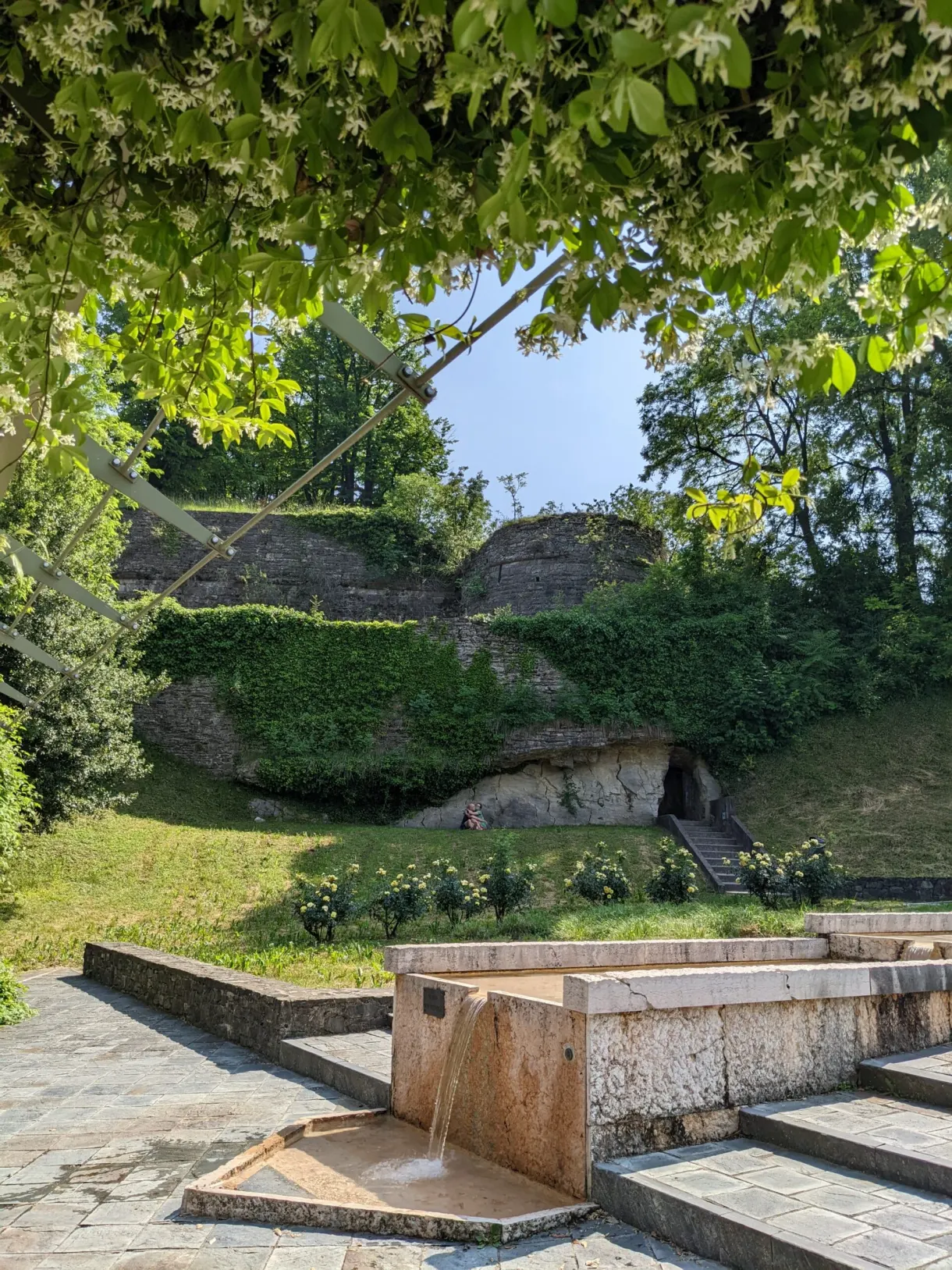 Abreuvoir de pierre au pied d'un talus végétalisé