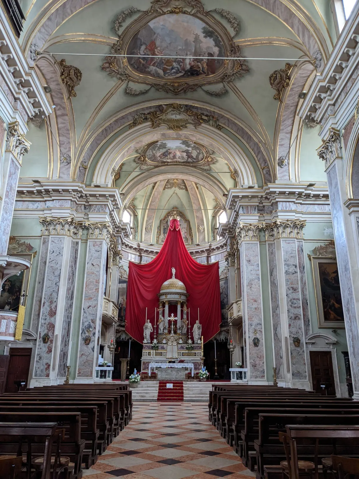 Nef baroque au sol en damier et tenture rouge