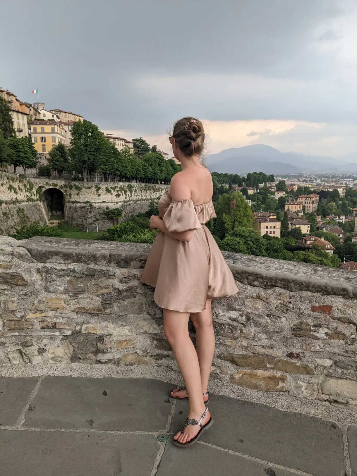 Femme de dos accoudée au rempart face au panorama