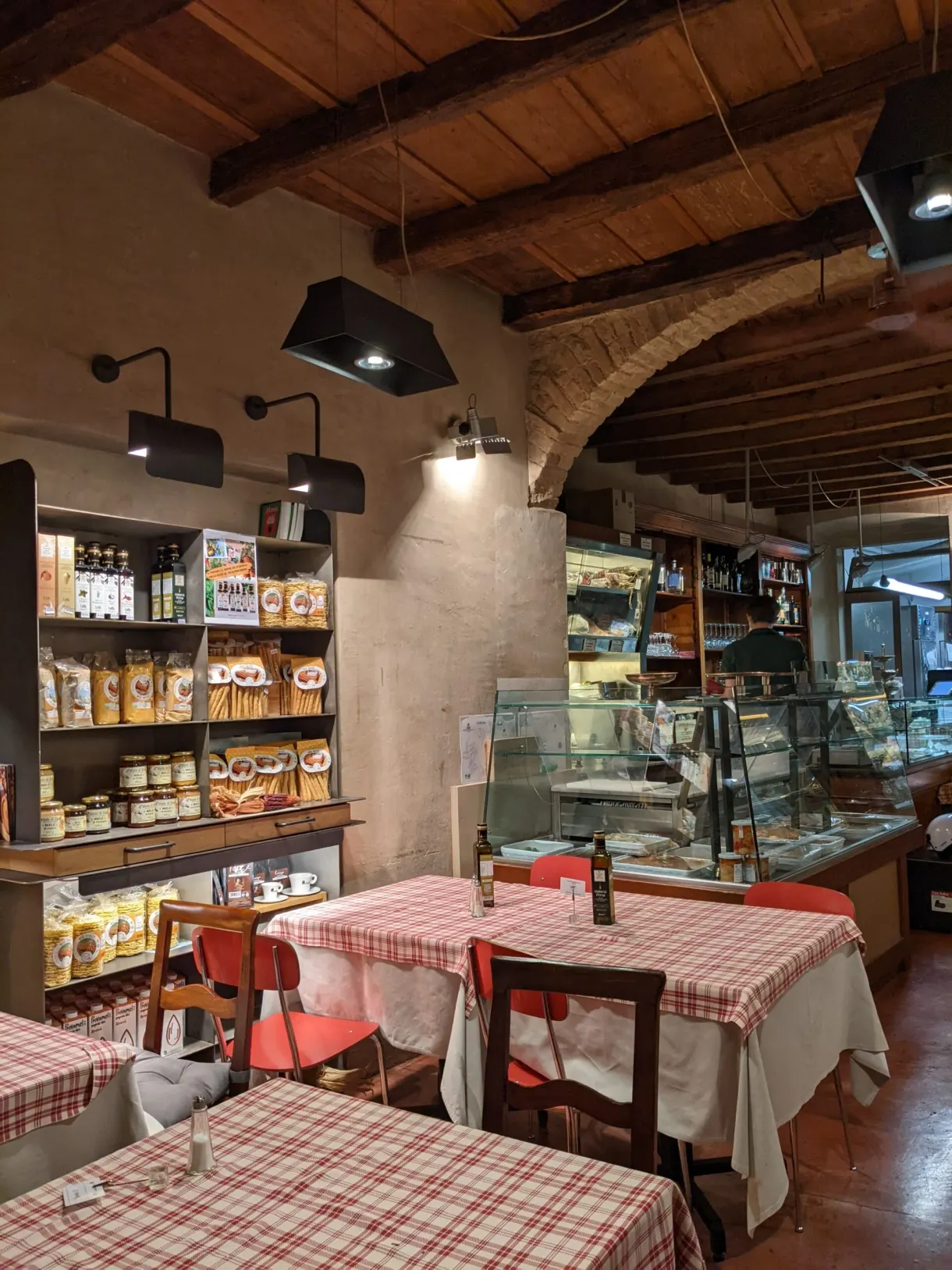 Salle de restaurant aux nappes à carreaux et poutres apparentes