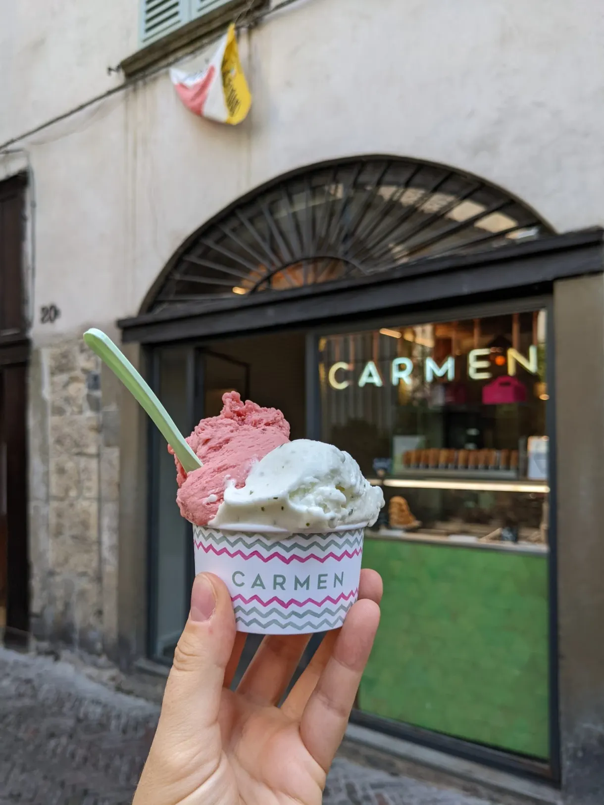 Glace à deux parfums devant la devanture d'un glacier