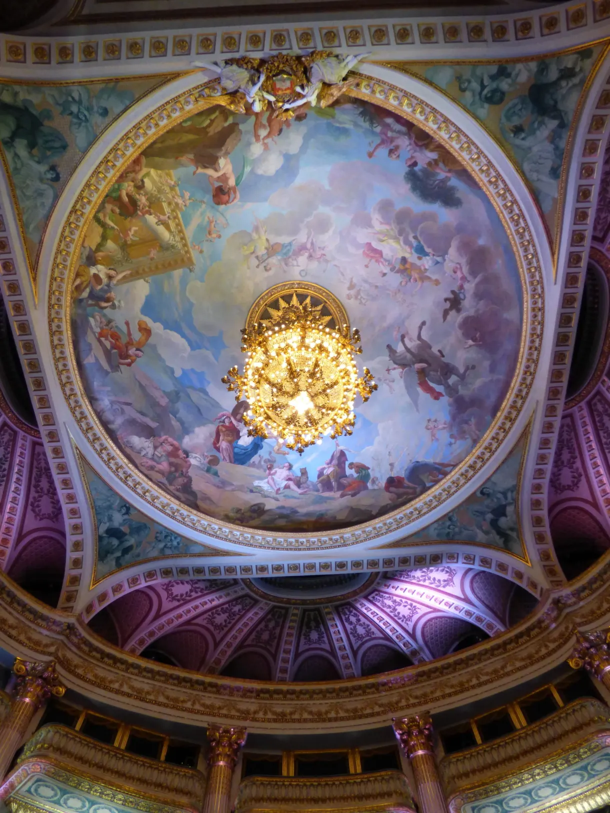 Plafond peint et grand lustre d'une salle de spectacle