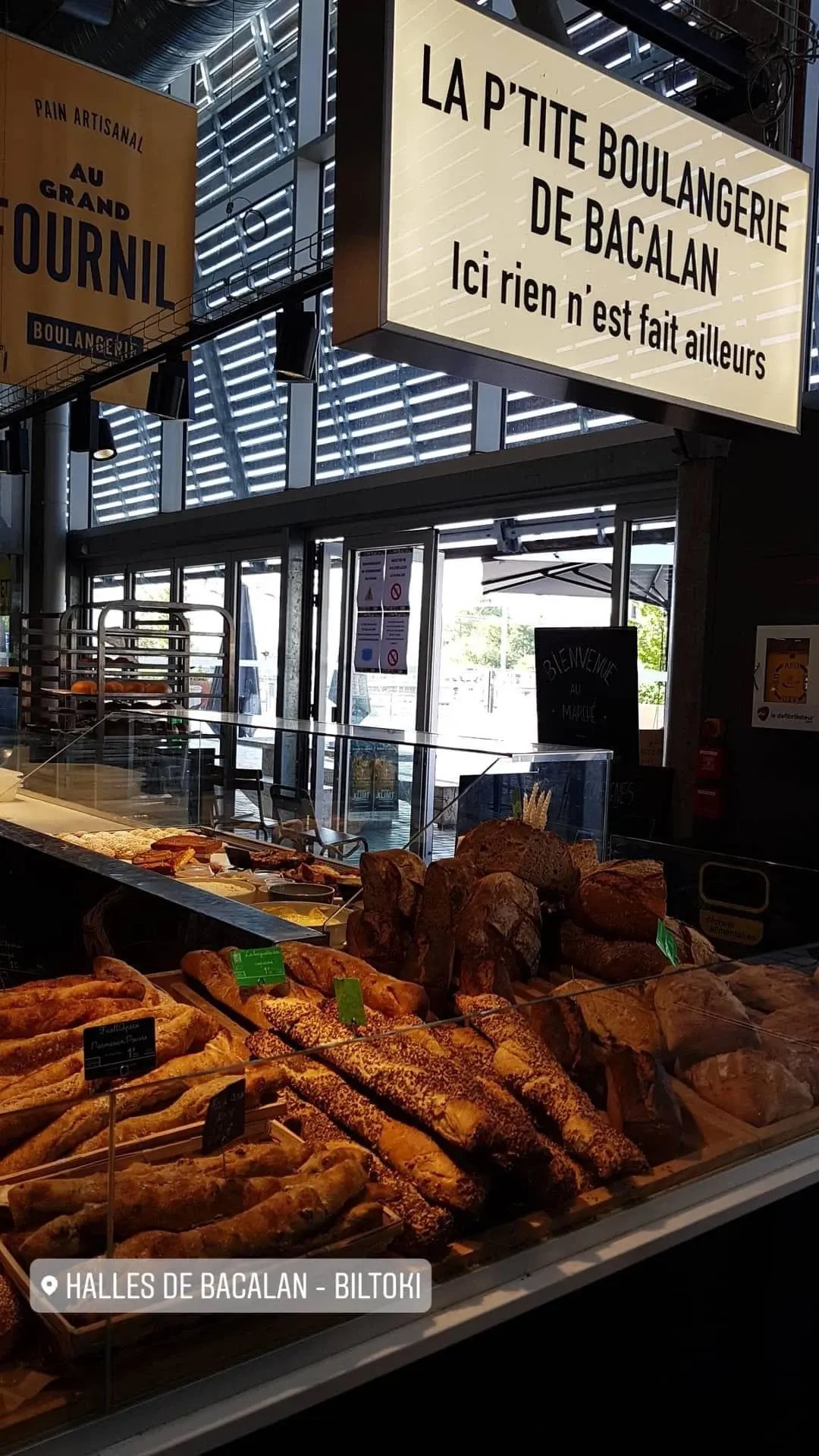 Vitrine de viennoiseries dorées sous l'enseigne d'une boulangerie de halle