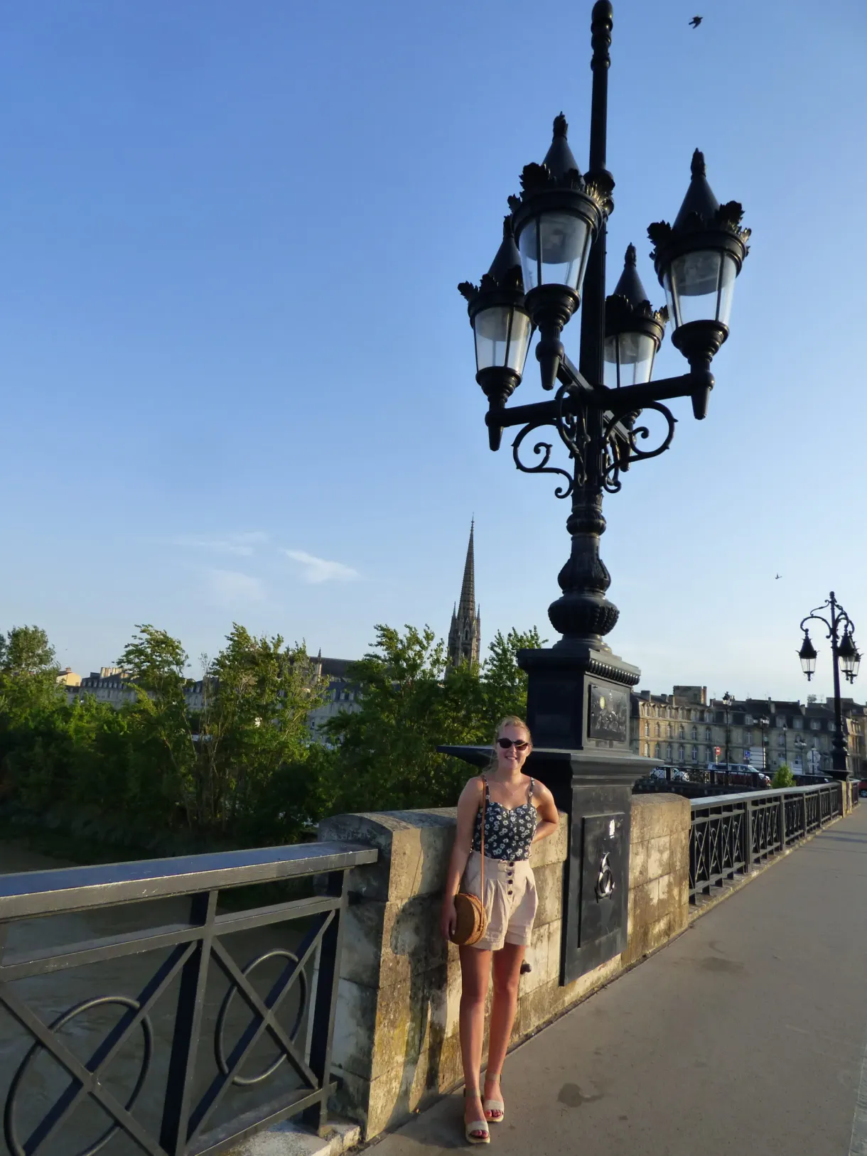 Femme debout sous un candélabre à cinq globes sur le pont