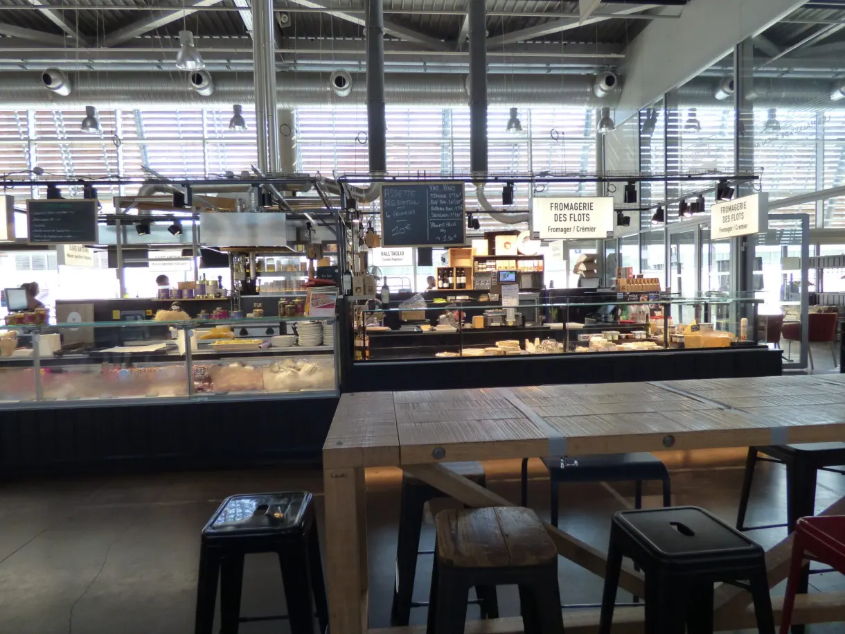 Tables hautes et comptoirs déserts à l'intérieur d'une halle gourmande