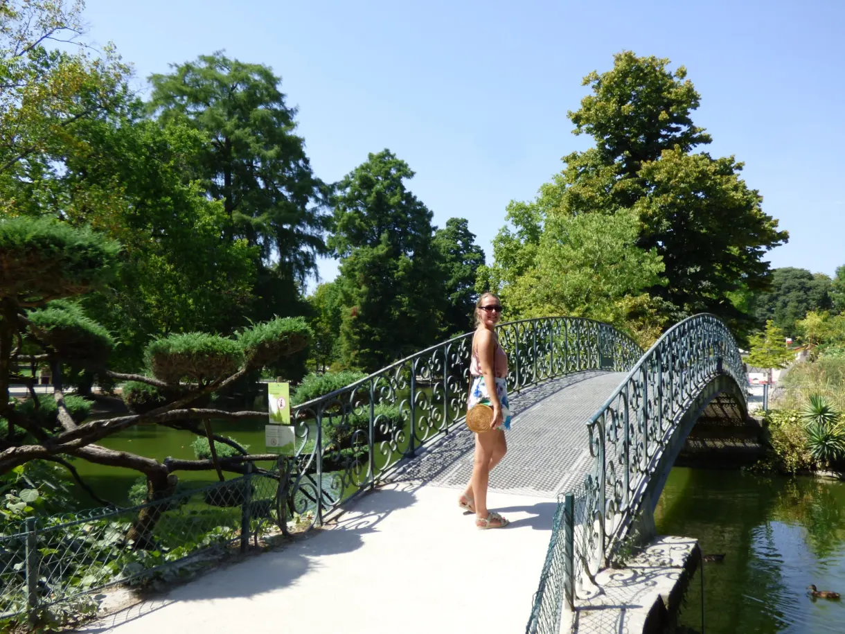Passerelle de fonte verte franchissant l'eau dans un parc