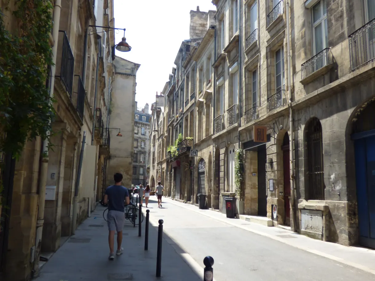 Rue étroite du vieux centre où marche un passant seul