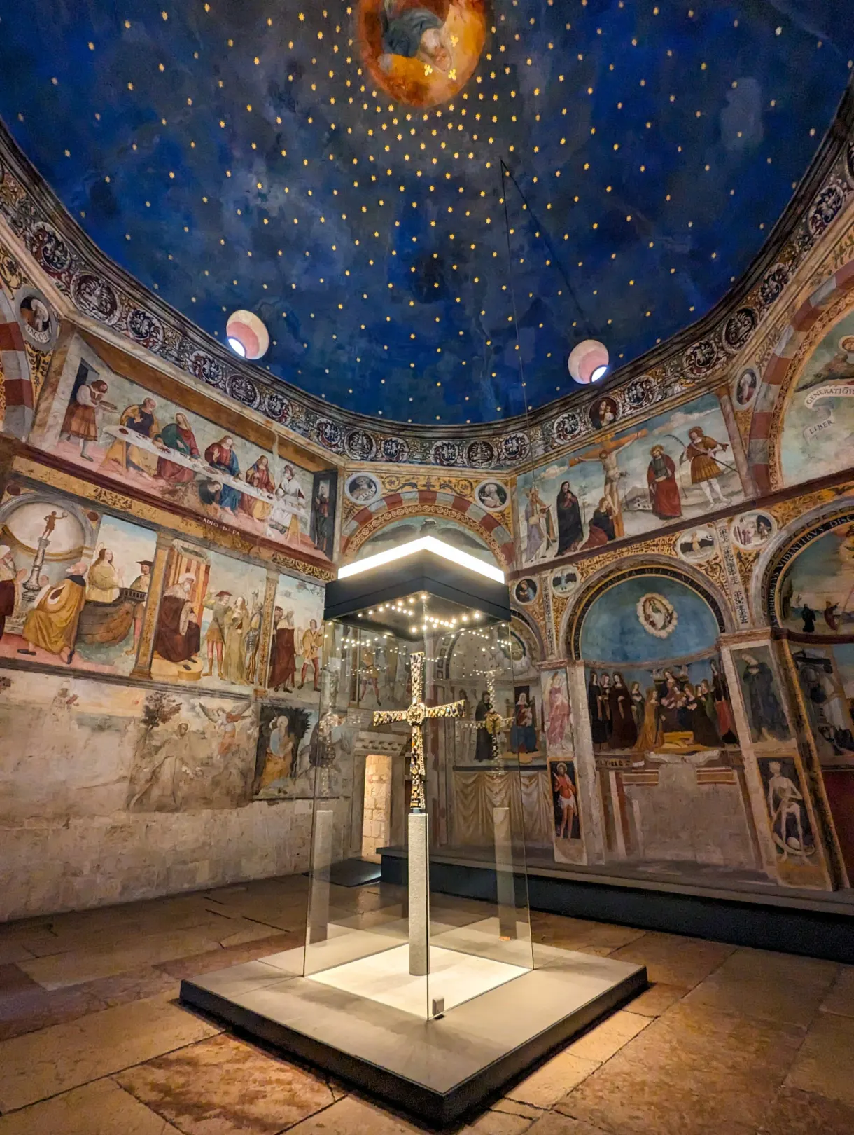 Croix médiévale exposée sous une voûte bleue étoilée