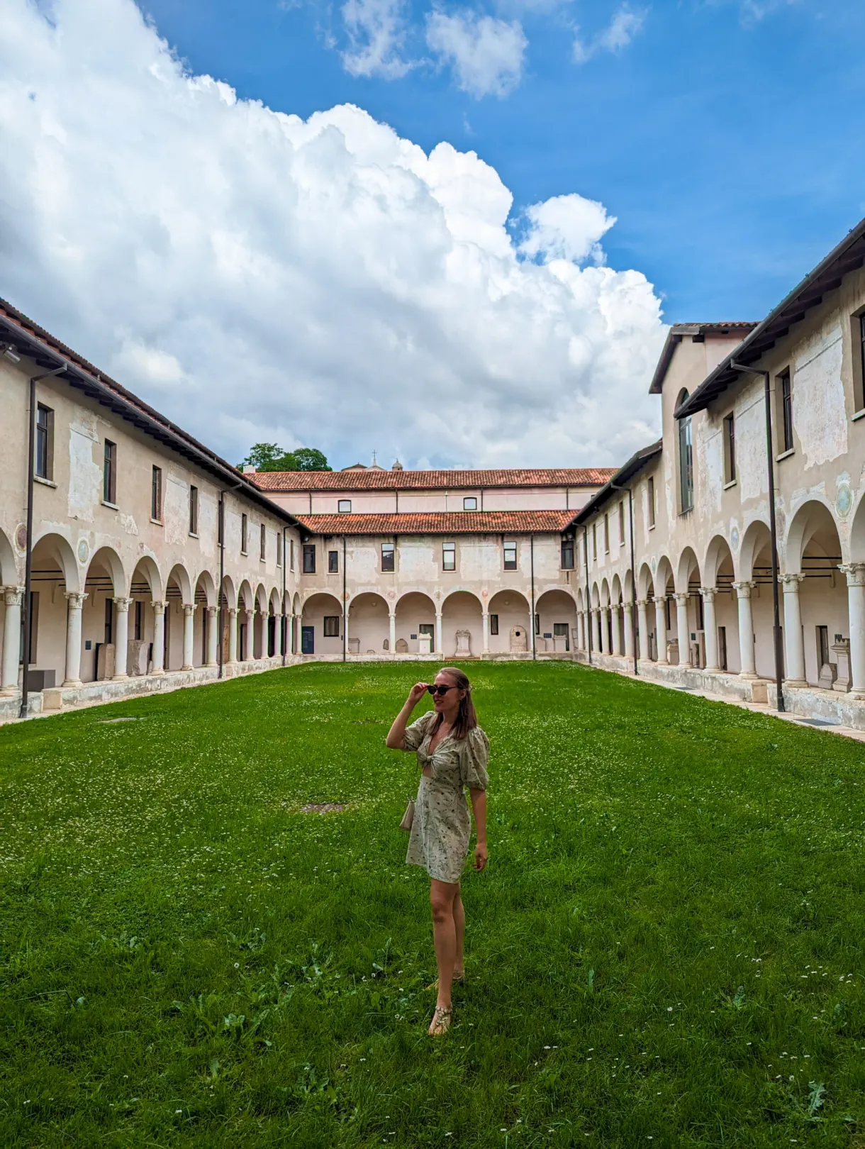 Visiteuse photographiant depuis la pelouse du cloître