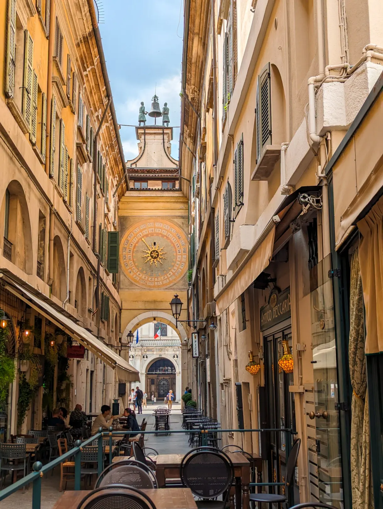 Horloge astronomique aperçue au bout d'une ruelle à terrasses