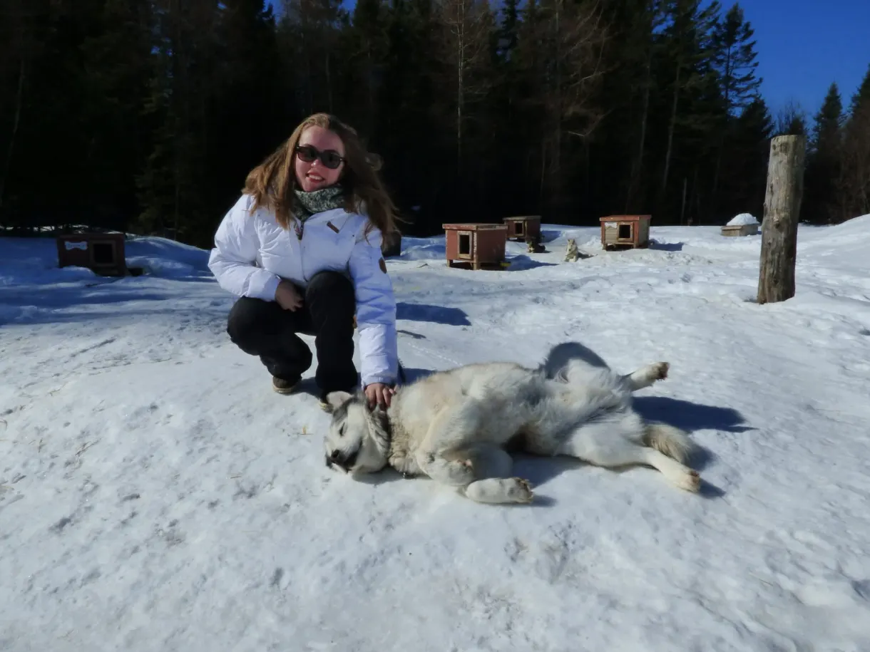 Visiteuse accroupie caressant un chien couché sur le dos