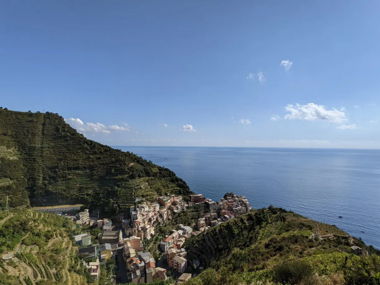 Terrasses cultivées surplombant un village blotti contre la mer