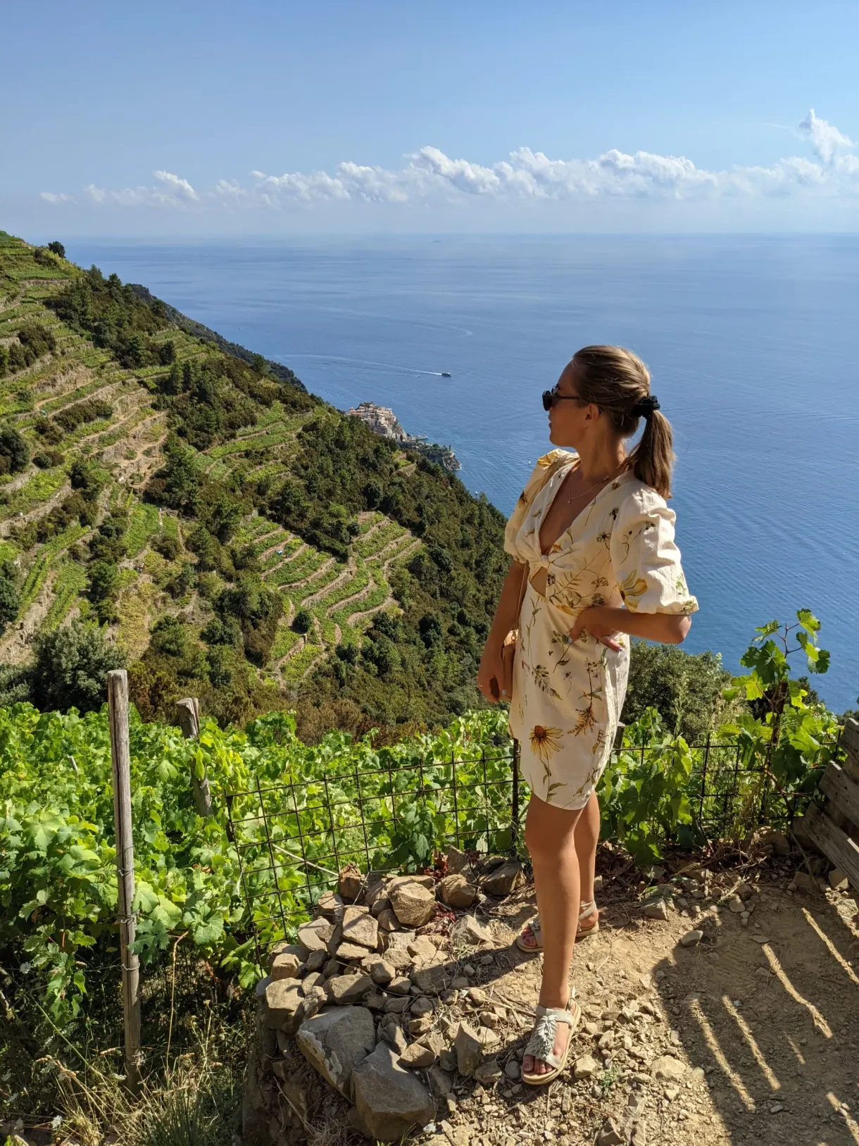 Femme sur le sentier, vignes et mer en contrebas