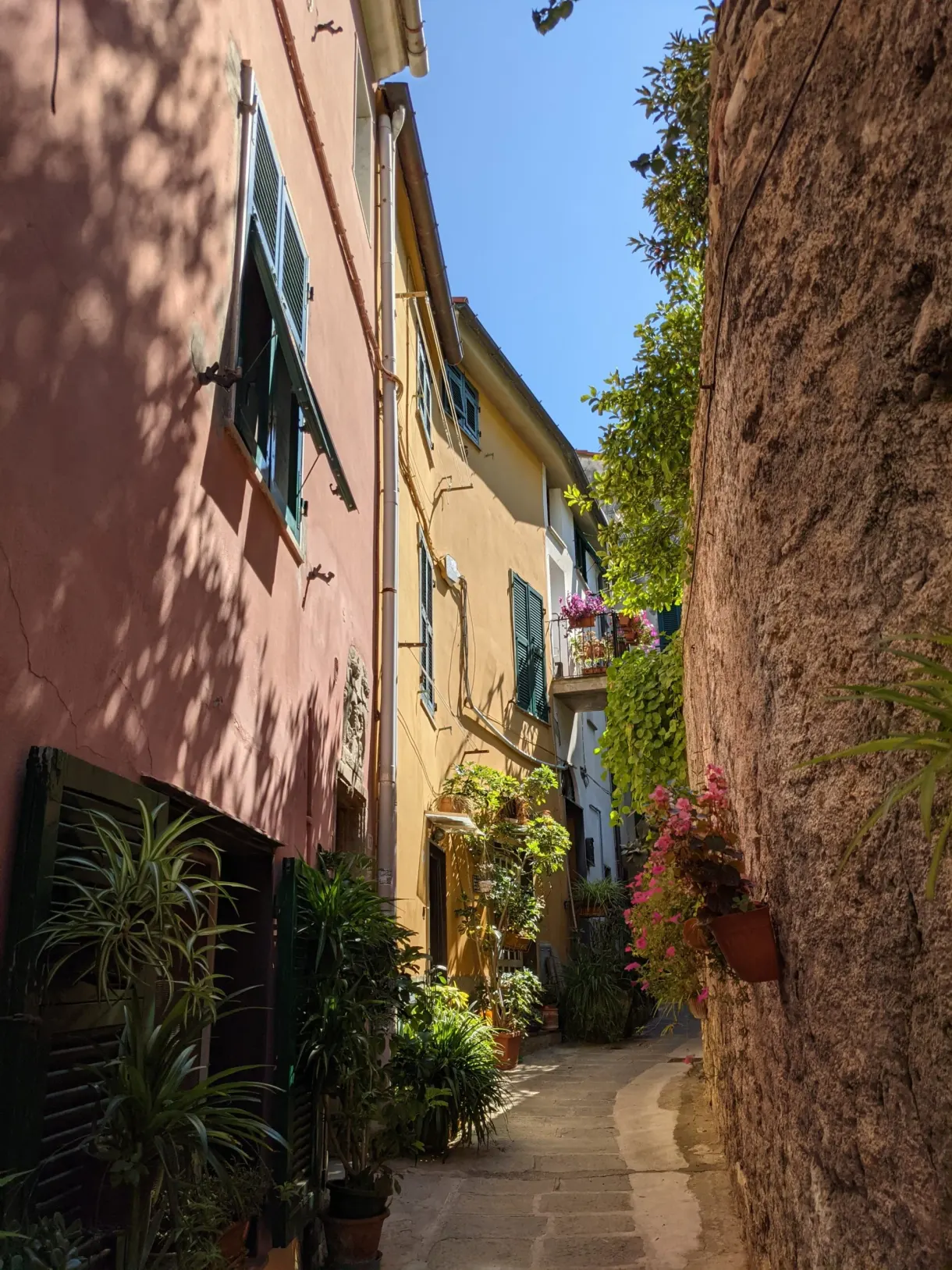 Ruelle coincée entre la roche brute et les maisons colorées