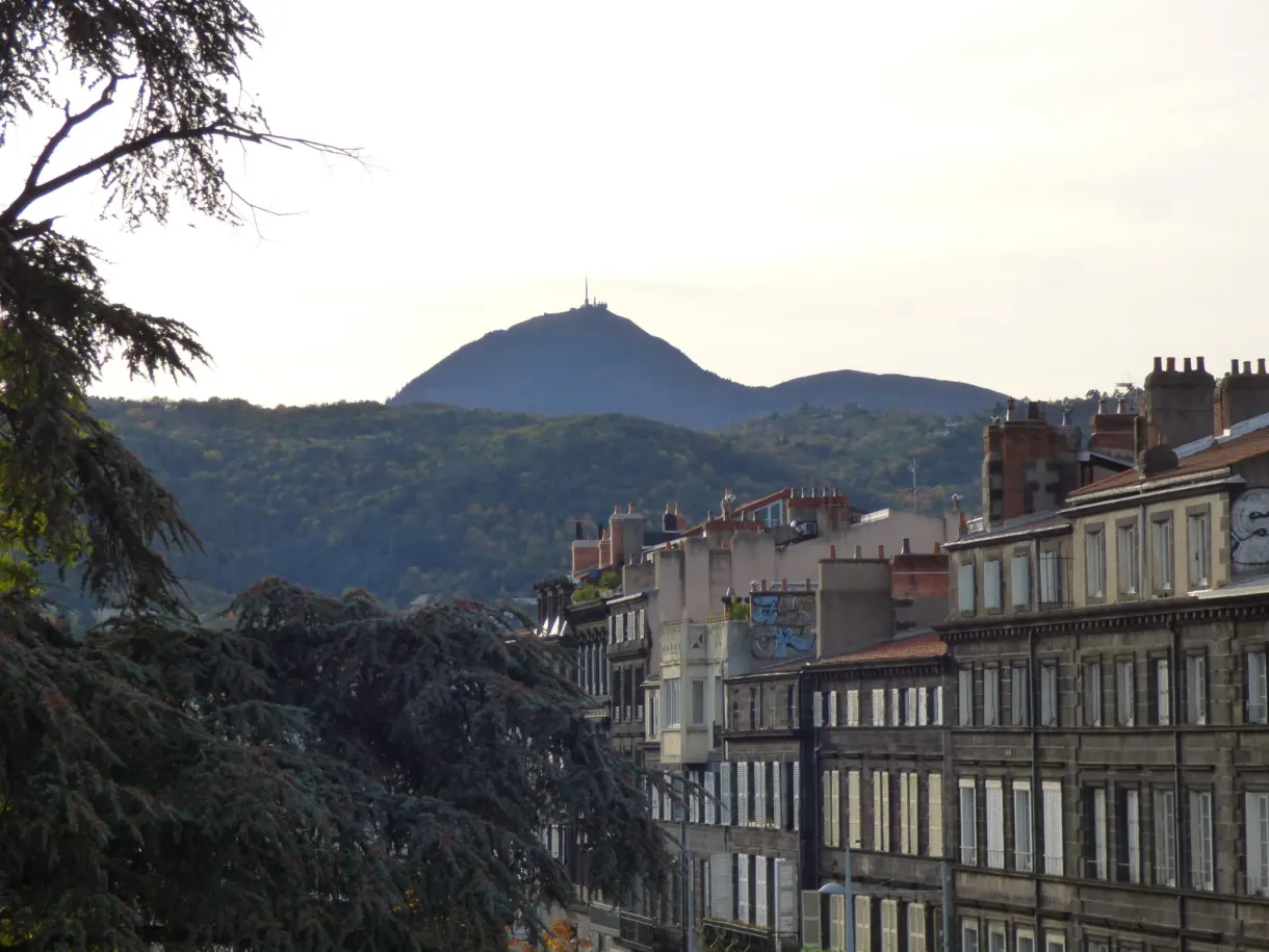 Puy de Dôme aperçu au bout d'une rangée d'immeubles