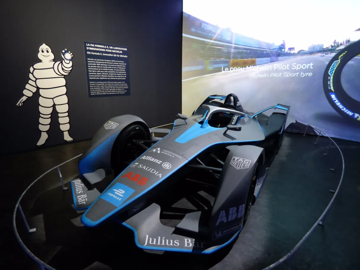 Monoplace de Formule E exposée près d'un Bibendum dessiné