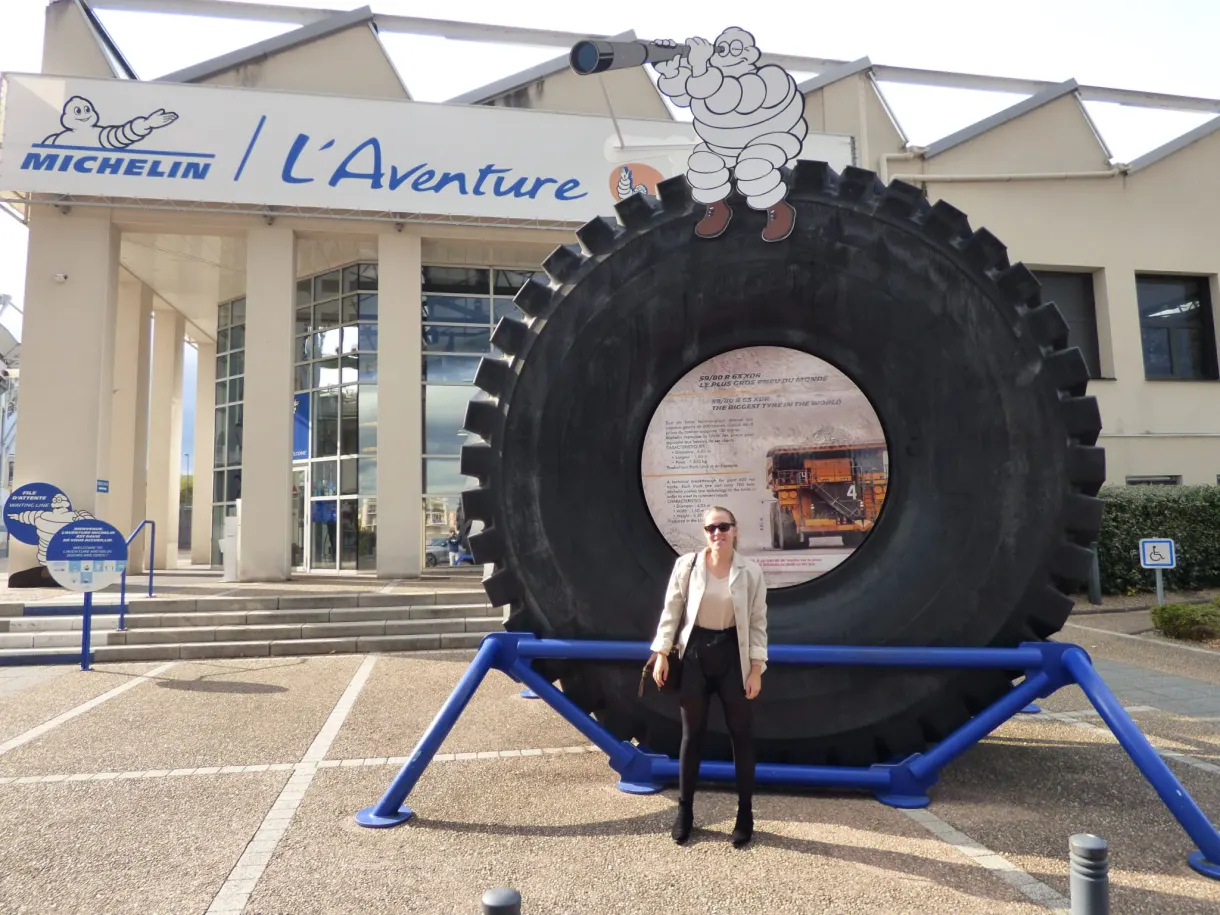 Pneu géant et visiteuse devant l'entrée de L'Aventure Michelin