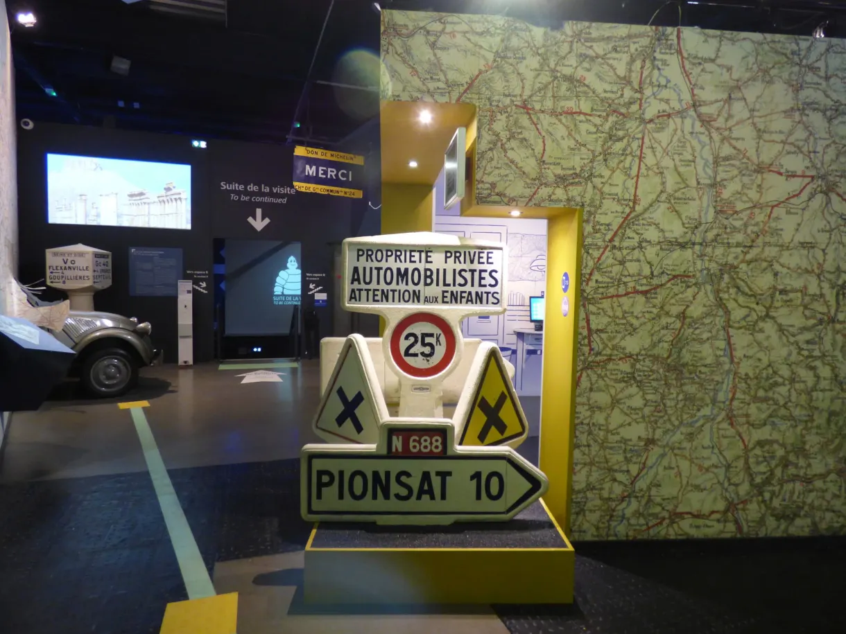 Panneaux routiers anciens dressés devant une carte murale