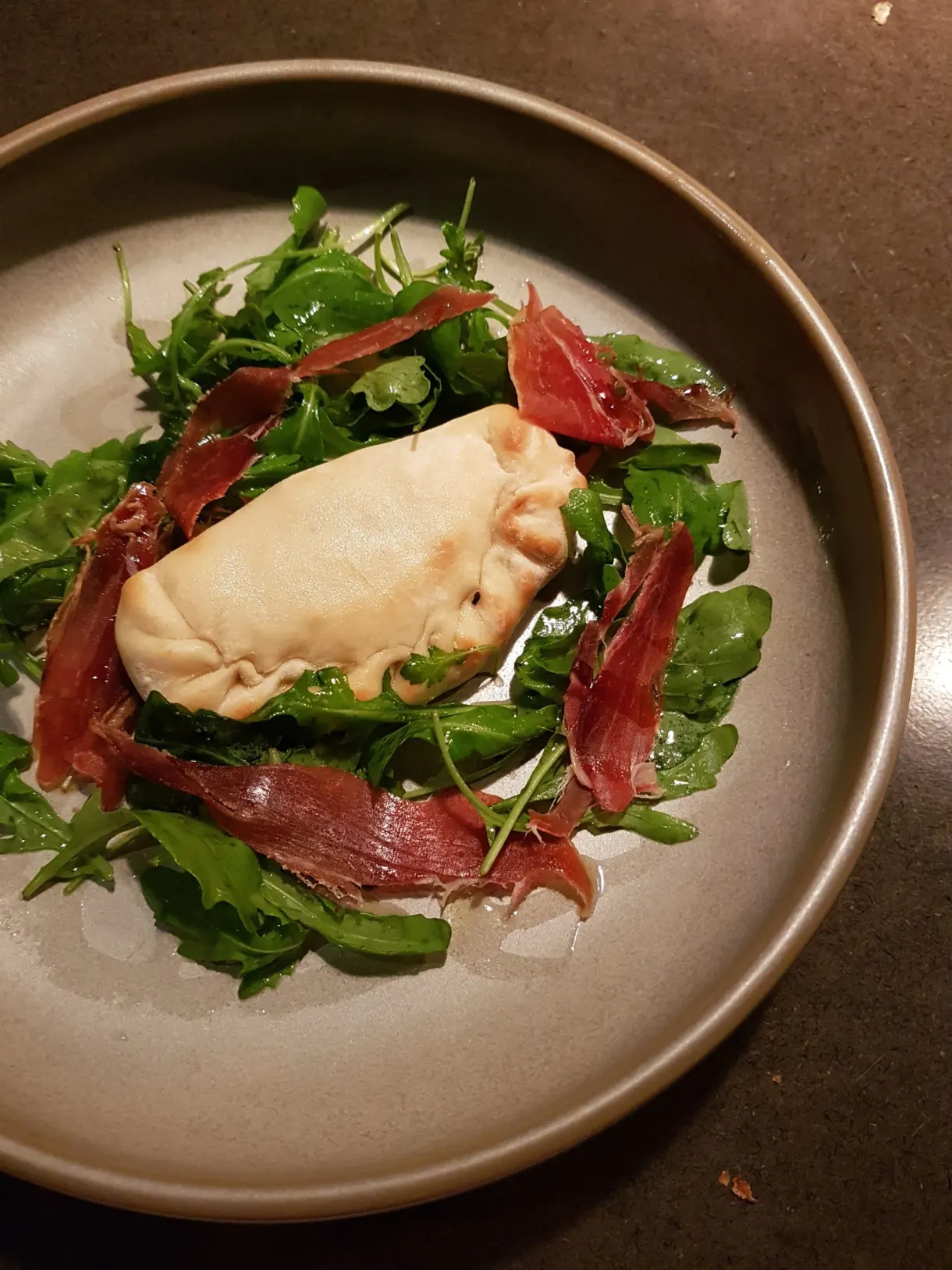 Feuilleté doré et jambon cru sur un lit de roquette