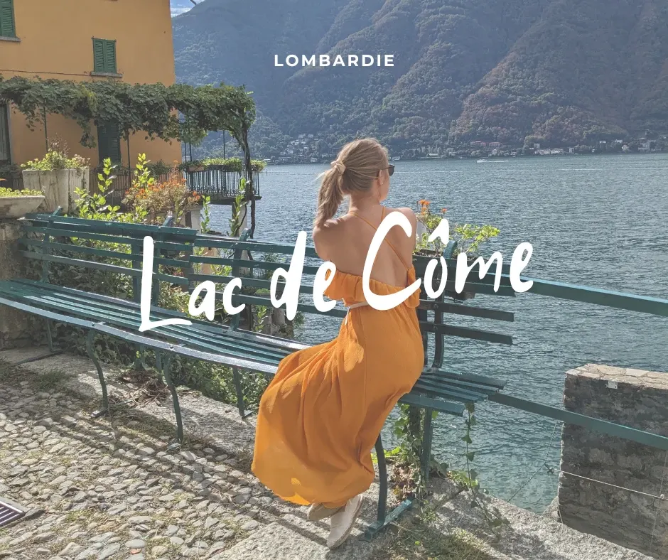 Femme en robe orange assise sur un banc face au lac