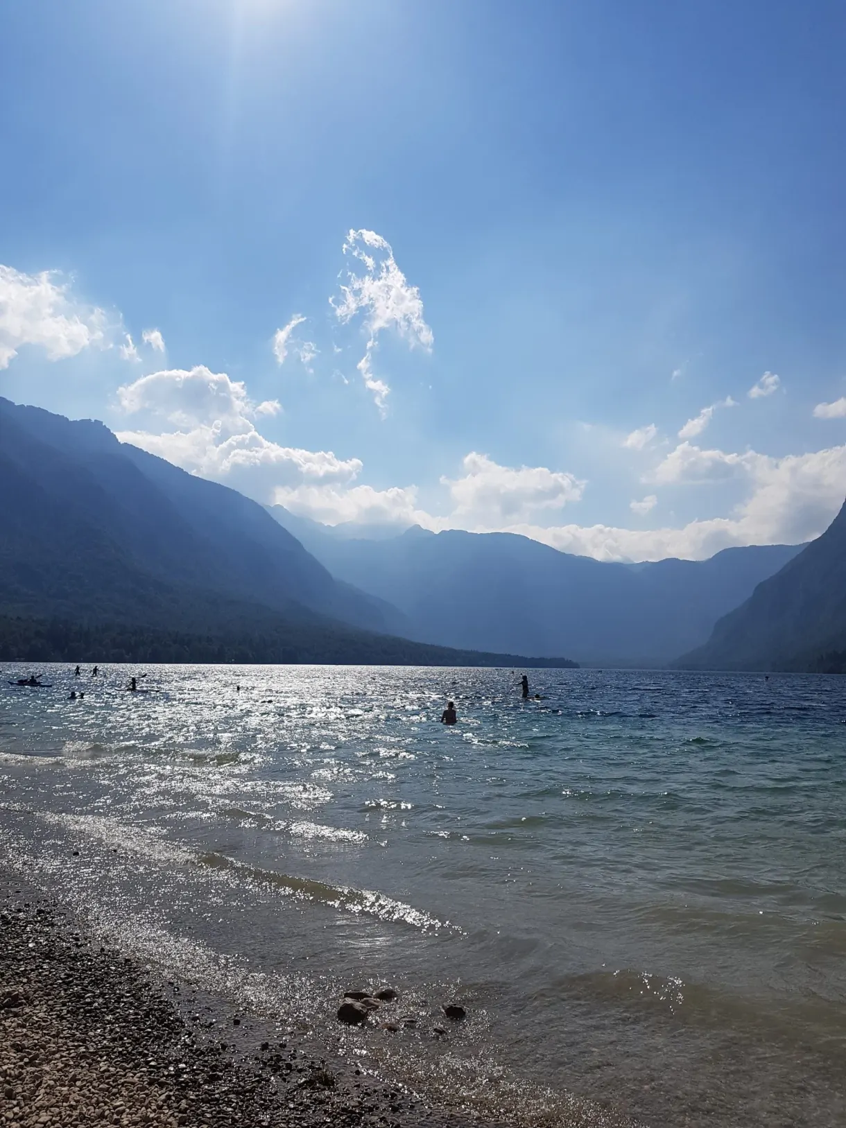 Baigneurs à contre-jour au bord du lac en fin d'après-midi