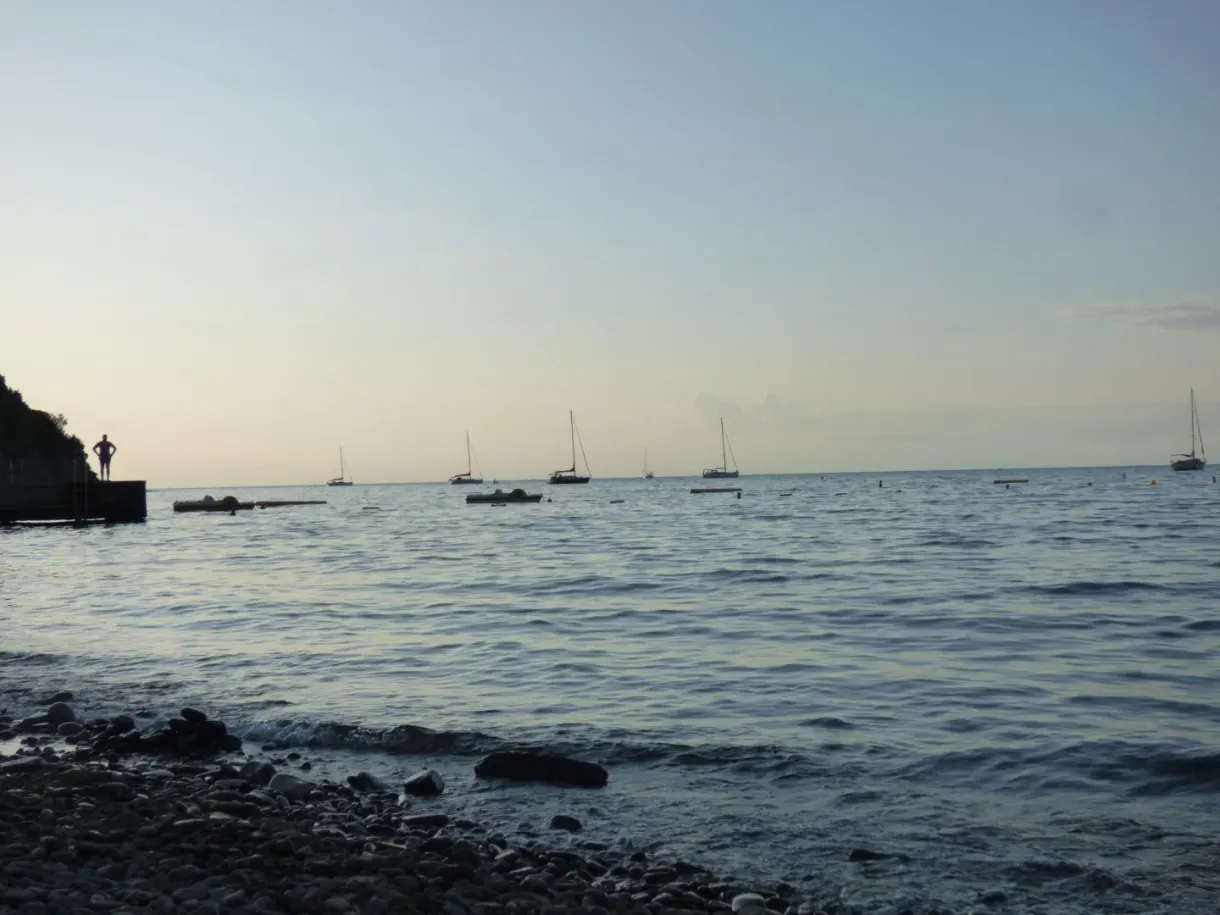 Galets et voiliers au mouillage dans la lumière du soir