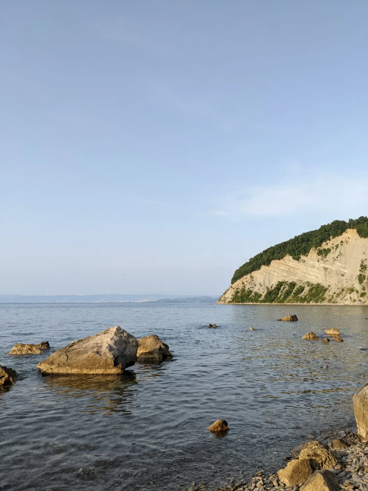 Rochers émergés devant la paroi claire de la falaise