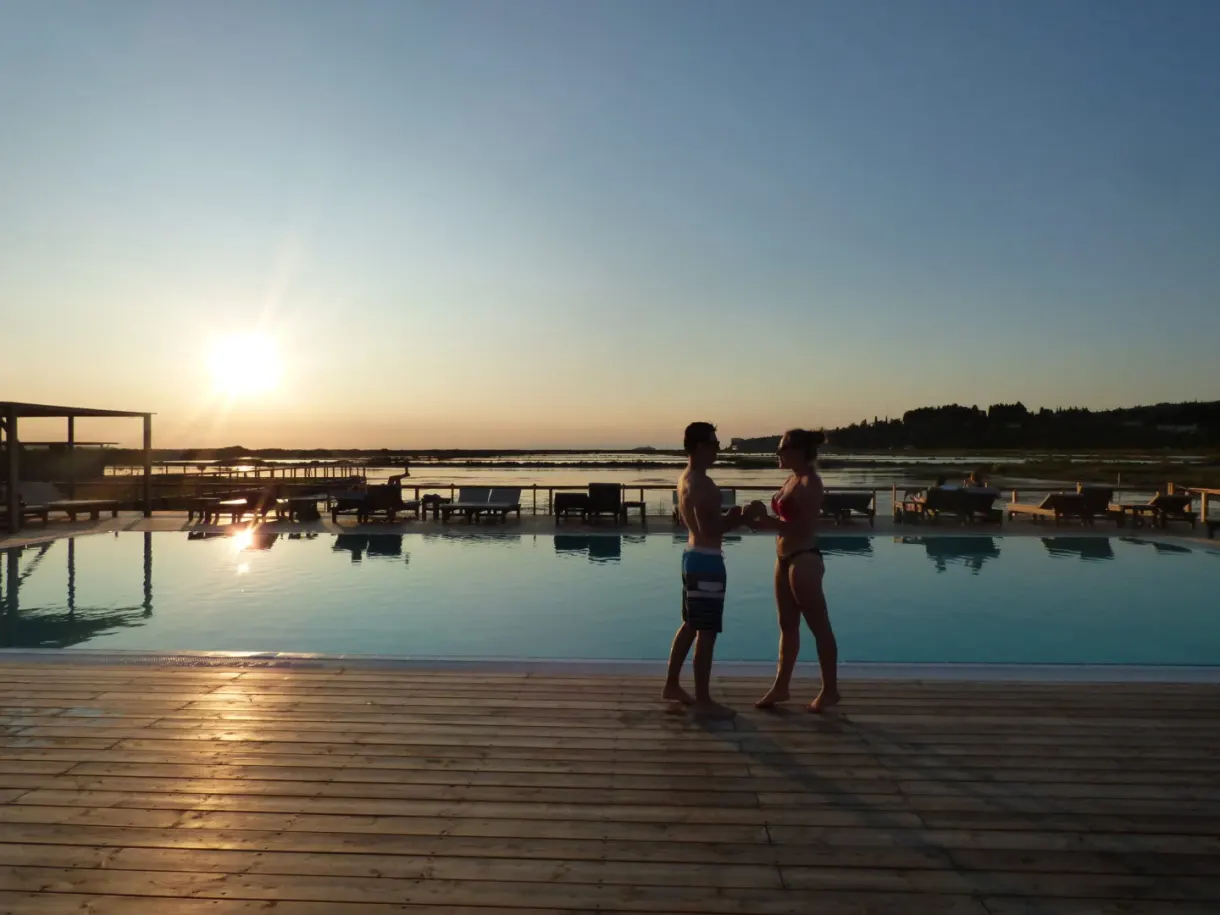 Couple au bord de la piscine à débordement au crépuscule