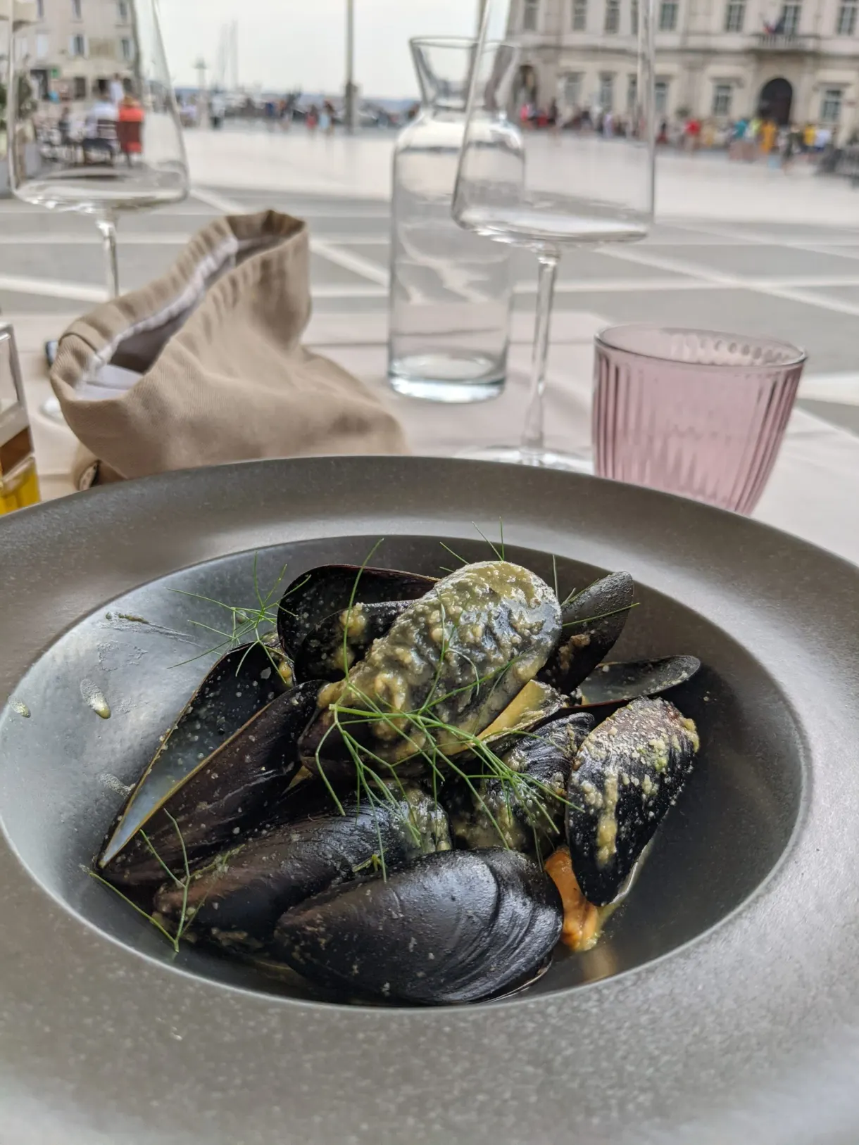 Assiette creuse de moules servie face au quai