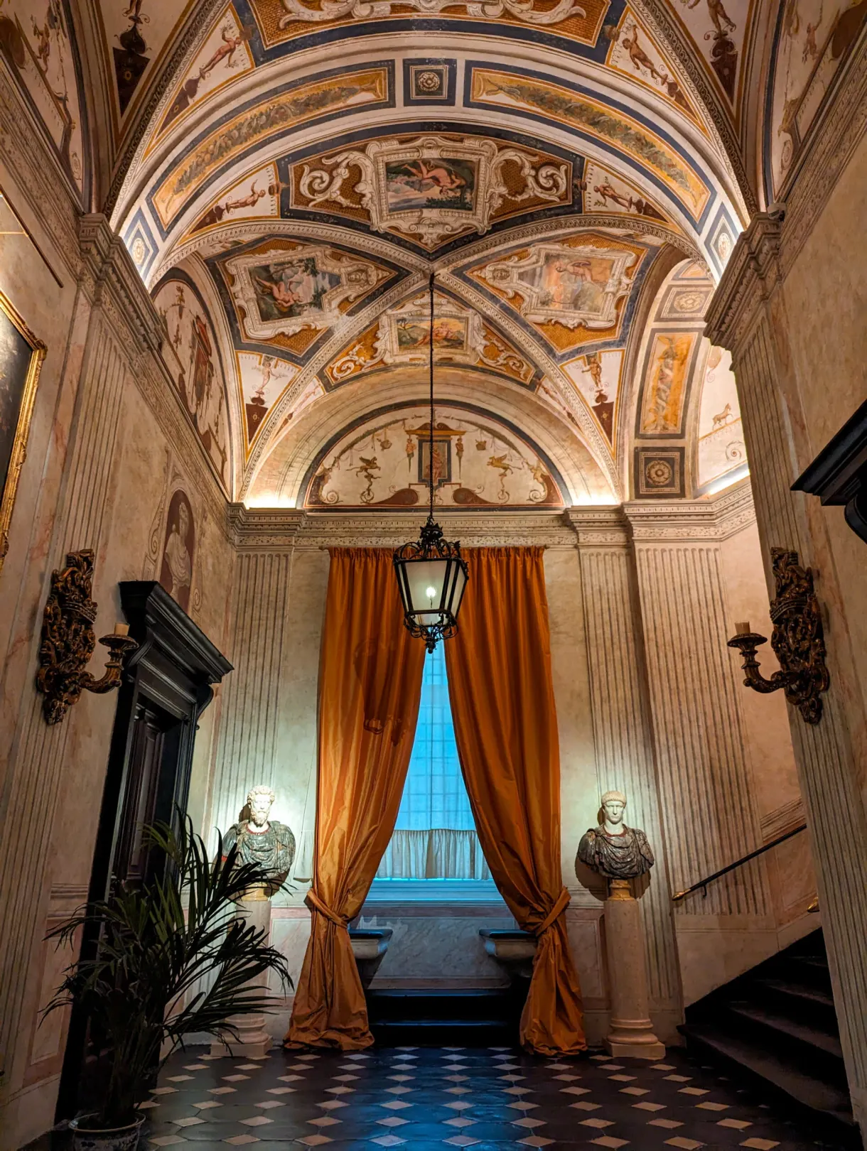 Vestibule de palais au plafond peint, rideau orange et lanterne suspendue