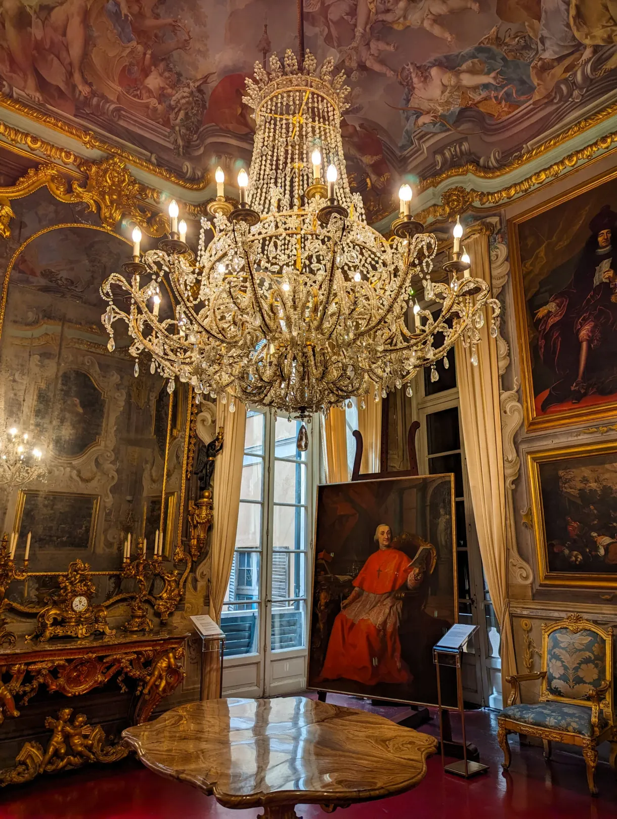 Salon d'apparat avec lustre de cristal et portrait de cardinal
