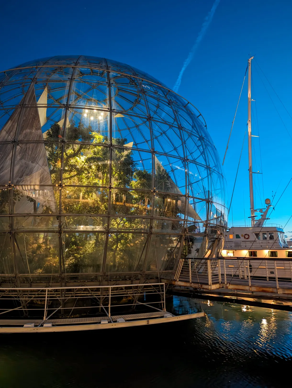 Sphère de verre végétalisée posée sur l'eau du port