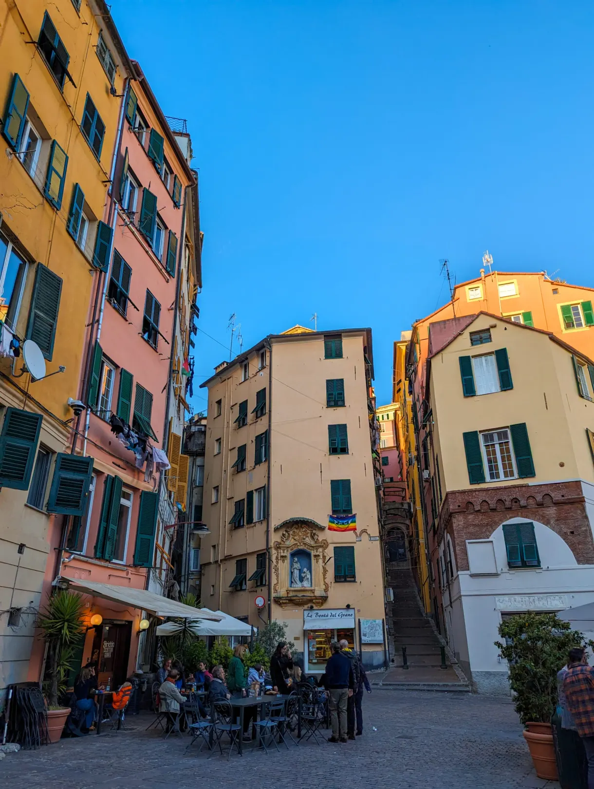 Terrasses de café sur une placette aux façades pastel