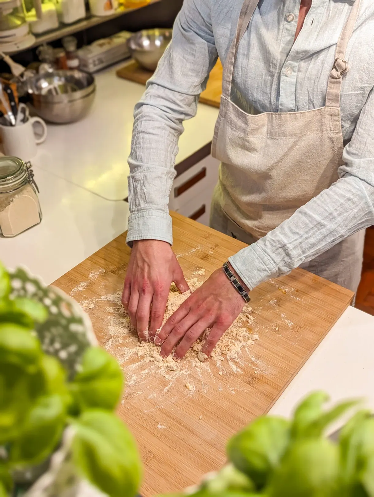 Mains rassemblant du parmesan râpé près de feuilles de basilic