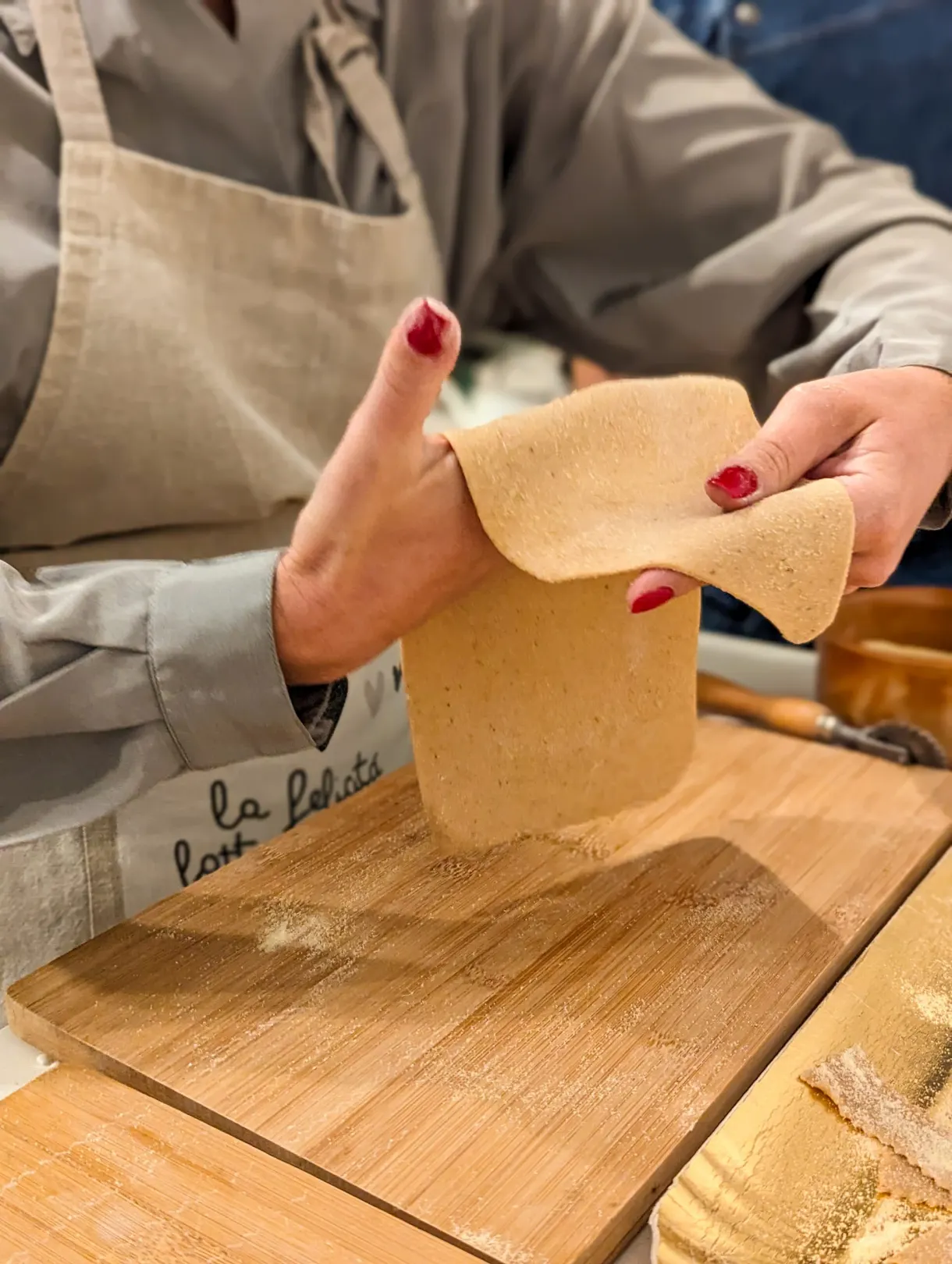 Feuille de pâte fraîche étirée à la main au-dessus d'une planche