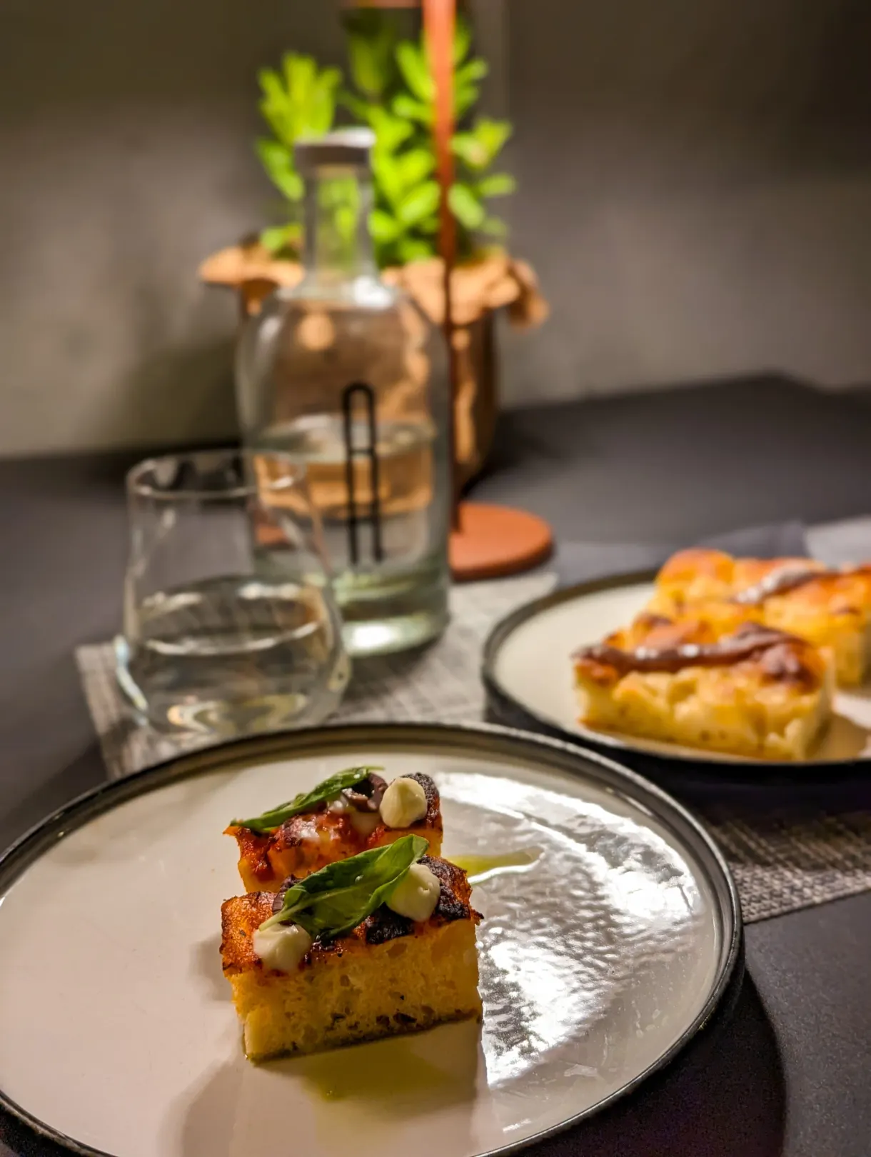 Parts de focaccia et assiette dressée sur une table de restaurant