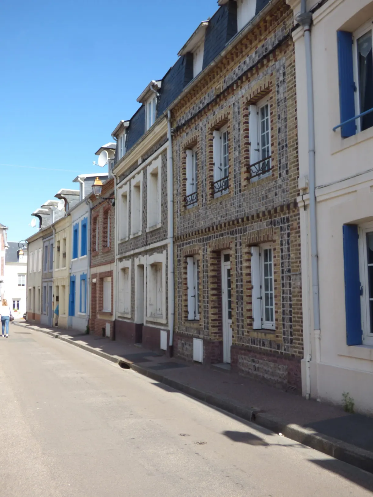 Rue d'Yport bordée de maisons en brique et silex aux volets bleus