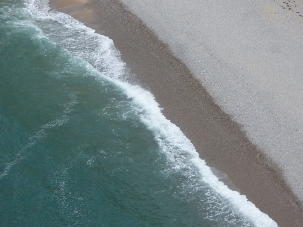 Écume des vagues venant lécher le banc de galets