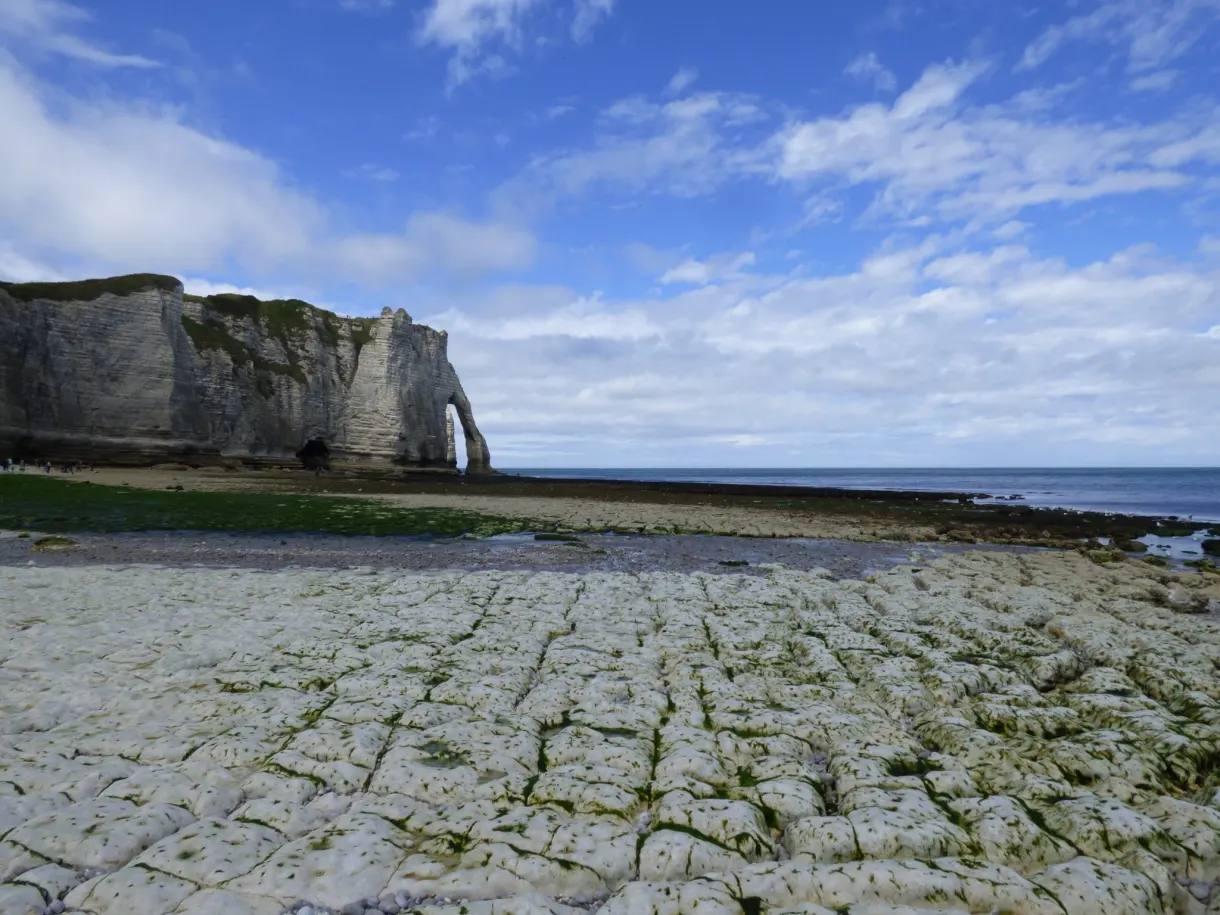 Dalle rocheuse découverte par la marée devant la falaise percée