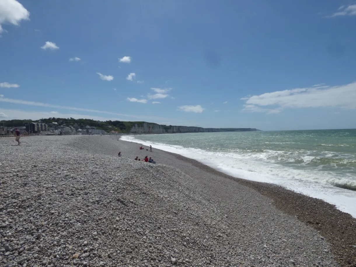 Plage de galets et vagues sous un ciel d'été dégagé