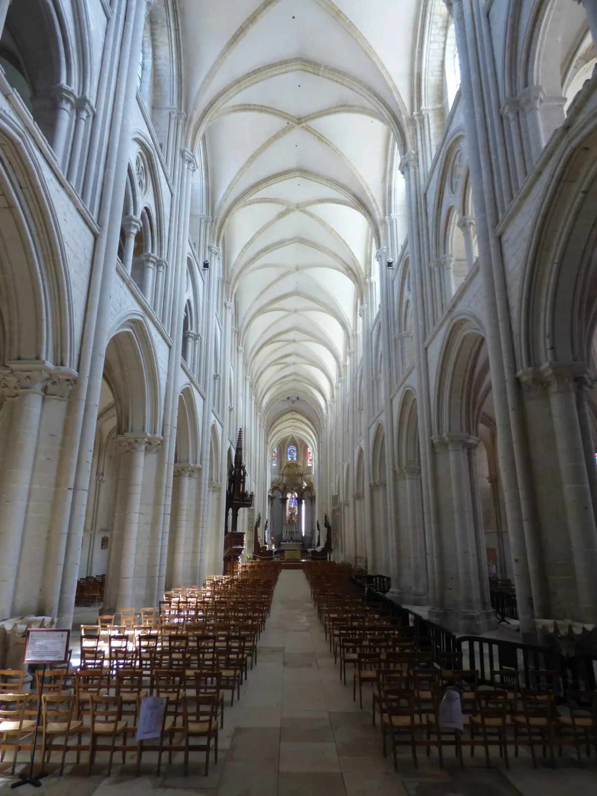 Nef gothique claire de l'abbatiale de la Trinité, chaises alignées