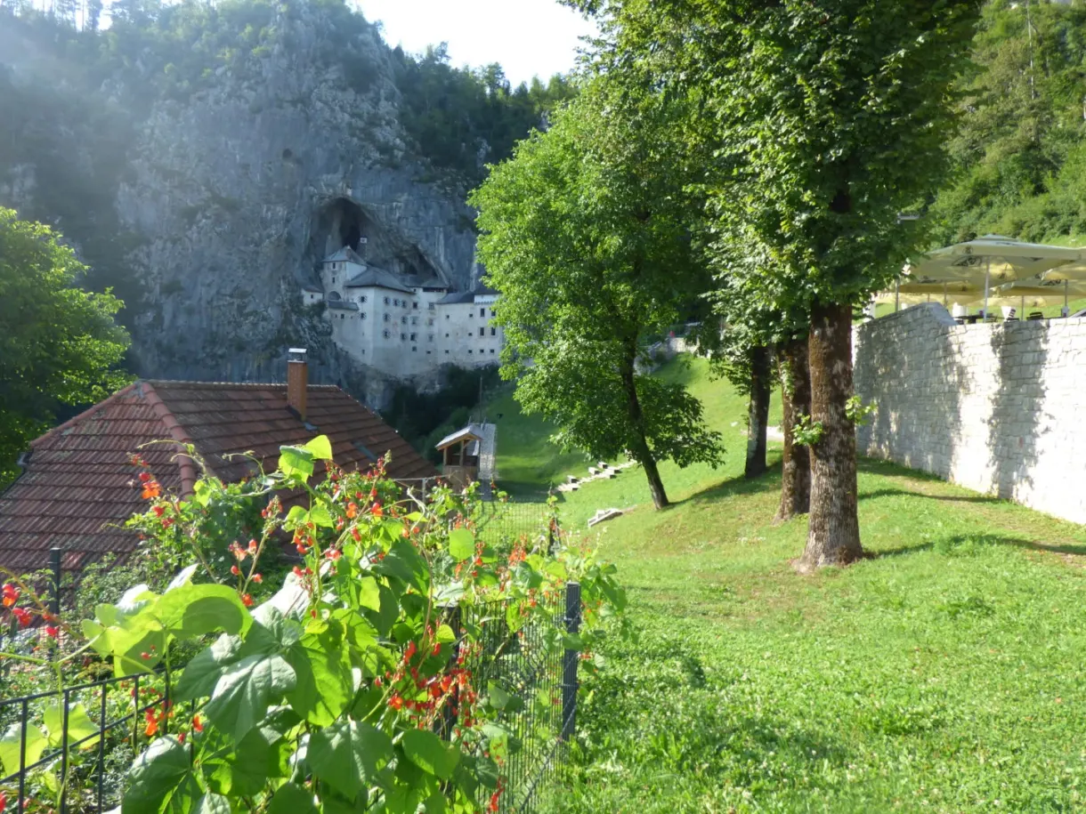 Castle at the far end of the meadow behind a flowering garden